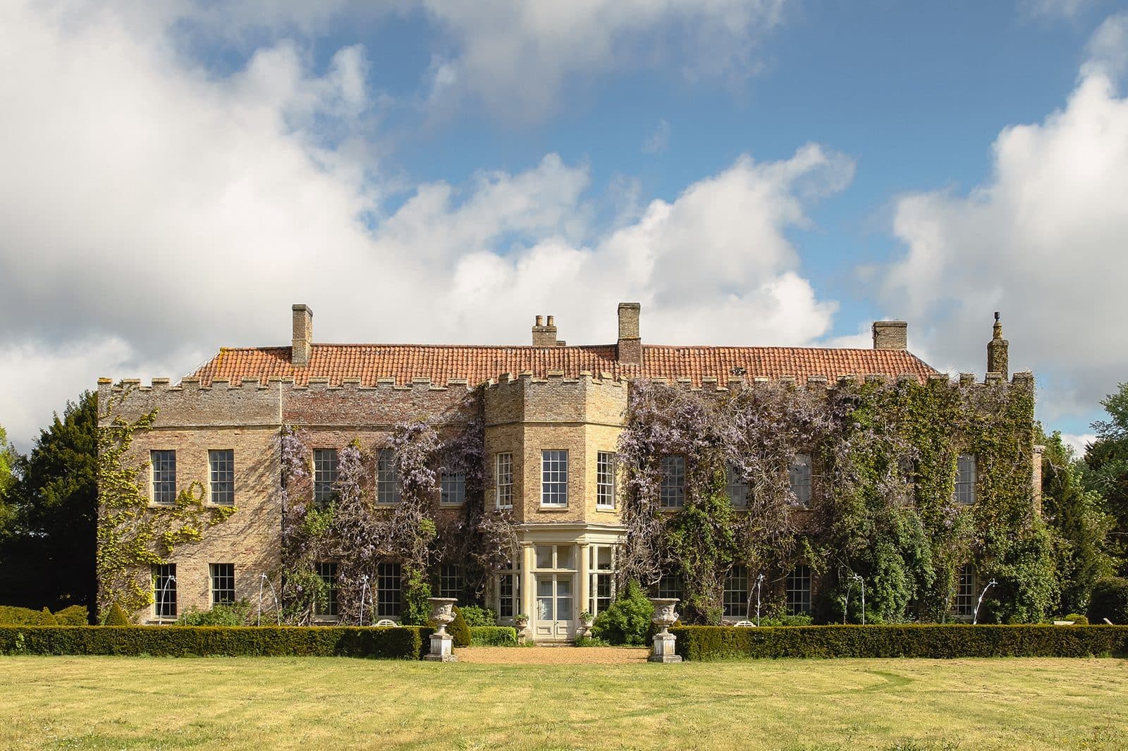 The front elevation of Narborough Hall — wisteria across five-hundred-year-old brick